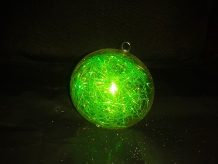Esfera transparente rellena de verde $65.00 la docena